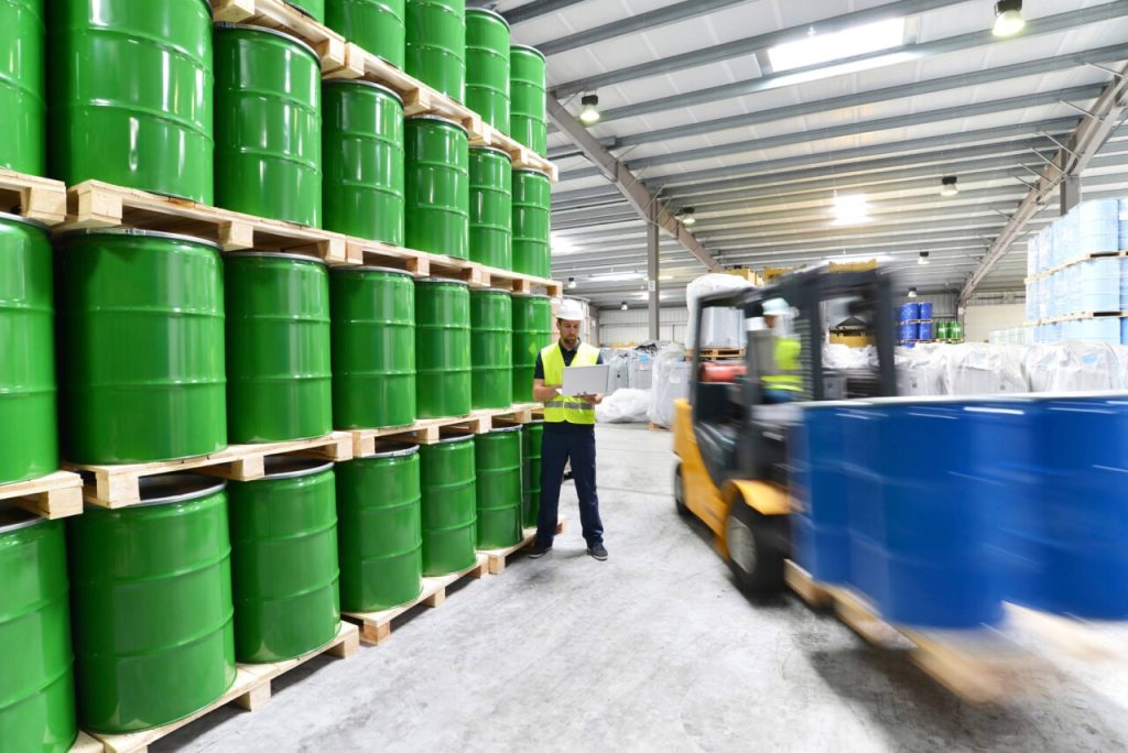 Worker in a warehouse completing a safety audit on a device