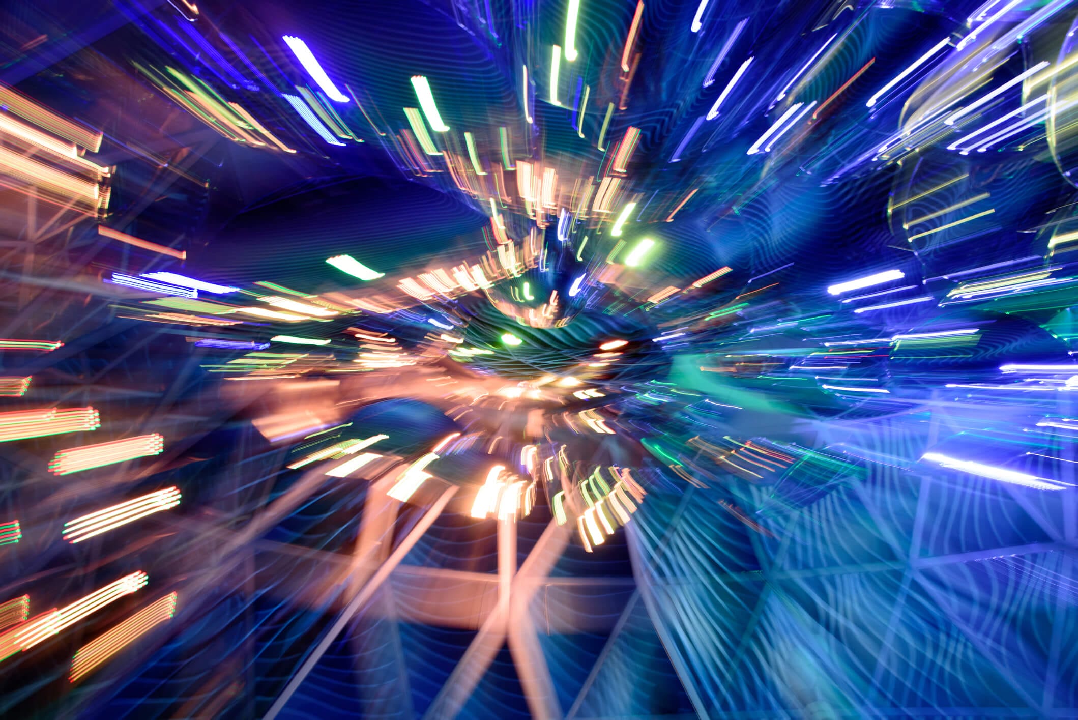 Blurred, colorful lights radiate from the center, creating a dynamic, abstract, and vibrant visual effect reminiscent of modern data visualization.