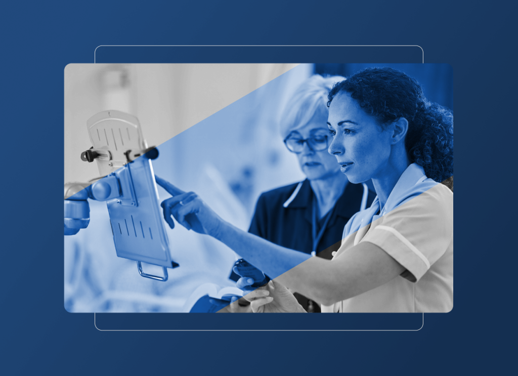 Two nurses in scrubs interact with a tablet device mounted on a stand in a medical setting, representing collaboration in the hospital industry, with a blue overlay partially covering the image.