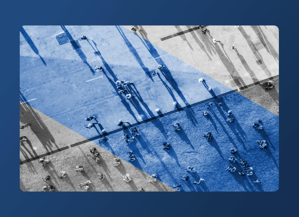 Aerial view of people casting long shadows on pavement with geometric blue shapes overlaying parts of the image, creating a visually abstract effect reminiscent of innovation in the pharma industry.